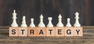 Strategy concept with chess pieces on wooden blocks spelling 'strategy'