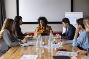 Colleagues having a strategy meeting around a conference table with charts and documents.