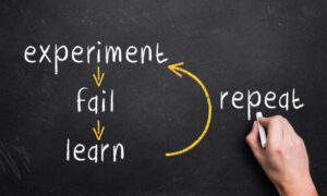 Chalkboard with the words 'experiment, fail, learn, repeat'
