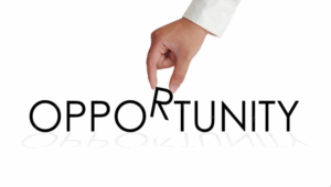 A hand is placing the letter "R" into the word "OPPORTUNITY"
